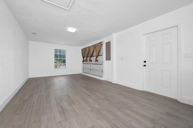 unfurnished living room featuring a textured ceiling and hardwood / wood-style flooring