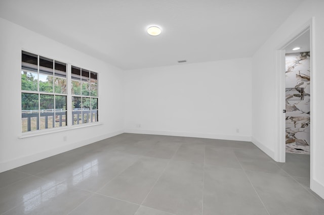 unfurnished room with tile floors