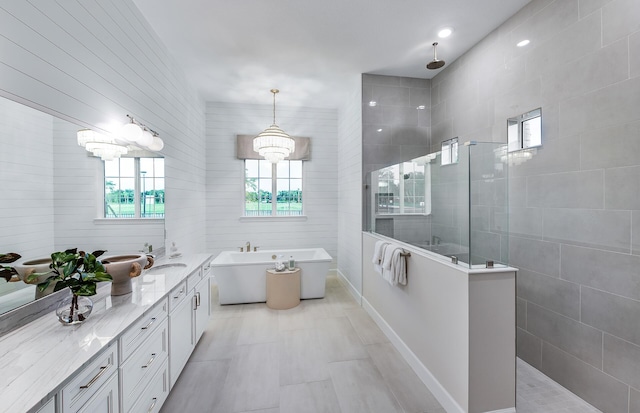 bathroom with vanity, independent shower and bath, and tile walls