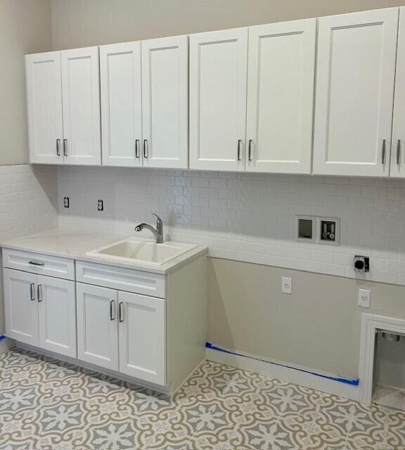 washroom with light tile patterned floors, hookup for a washing machine, cabinet space, a sink, and electric dryer hookup