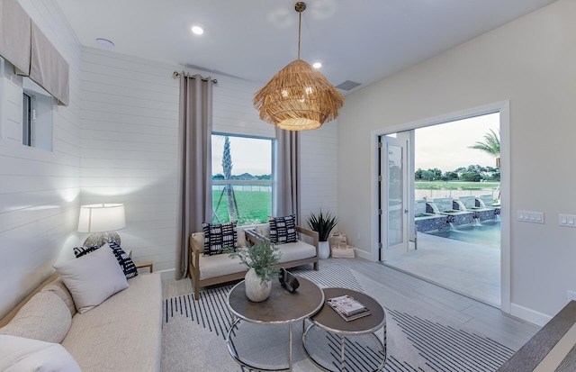 living room featuring visible vents, light wood-type flooring, a wealth of natural light, and baseboards