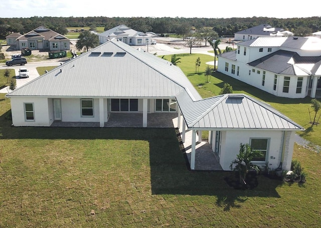 exterior space with a yard, metal roof, and stucco siding