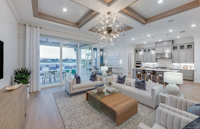 living room with coffered ceiling, beamed ceiling, a notable chandelier, light hardwood / wood-style floors, and ornamental molding