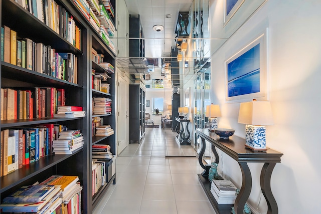 hall featuring built in shelves and light tile patterned floors