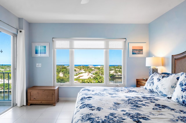 bedroom featuring multiple windows, access to outside, and light tile patterned floors