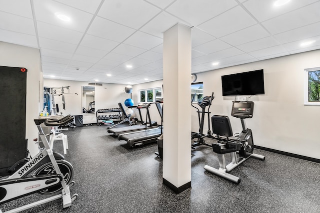 exercise room featuring a drop ceiling and a wealth of natural light