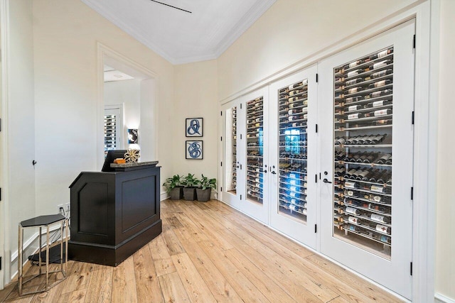 wine area featuring light hardwood / wood-style floors and crown molding