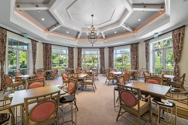 carpeted dining area with french doors, ornamental molding, a notable chandelier, and coffered ceiling