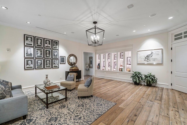 living room featuring crown molding, a notable chandelier, and light hardwood / wood-style floors