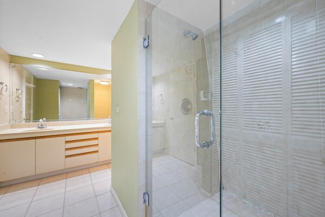 bathroom featuring a shower with shower door, tile floors, and vanity with extensive cabinet space