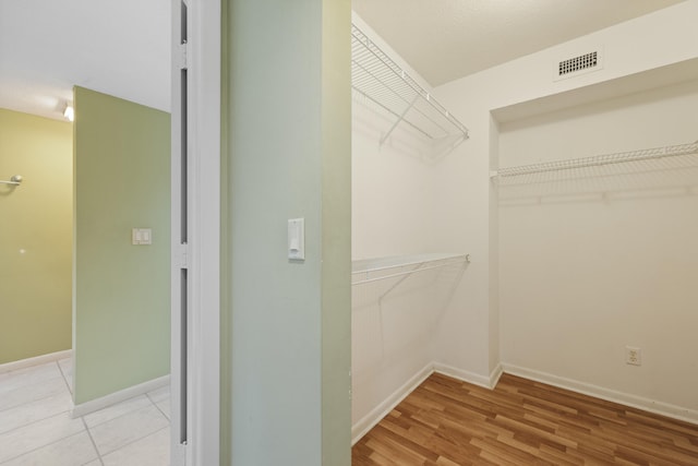 walk in closet featuring light tile floors