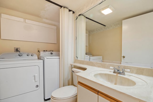 bathroom with washer and dryer, toilet, and vanity