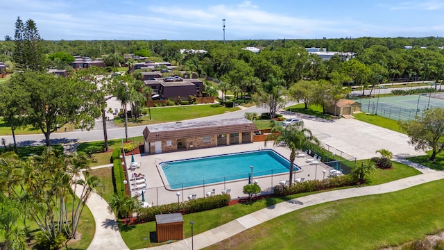 view of swimming pool featuring a lawn, a patio area, and tennis court