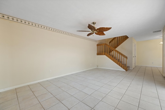 empty room with ceiling fan and light tile flooring