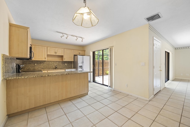 kitchen with dark stone counters, light tile flooring, stove, tasteful backsplash, and rail lighting