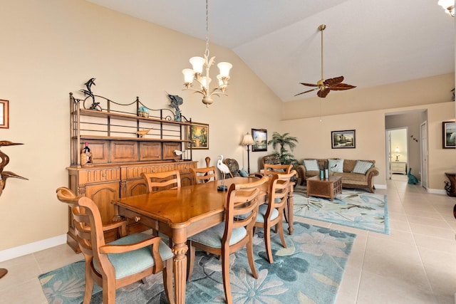 tiled dining space featuring high vaulted ceiling and ceiling fan with notable chandelier