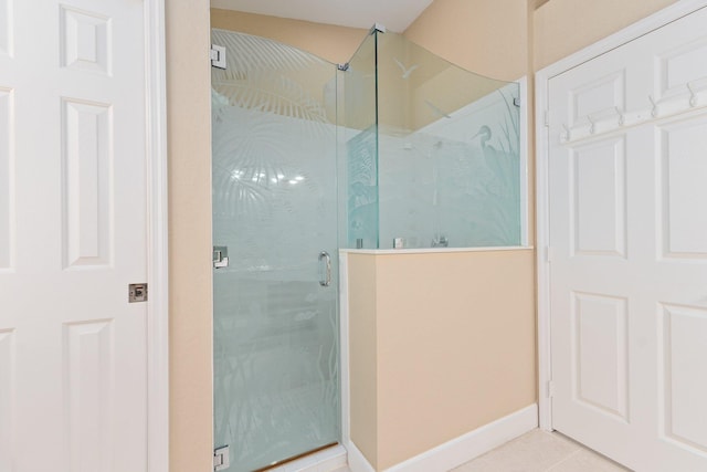 bathroom with tile flooring and a shower with door