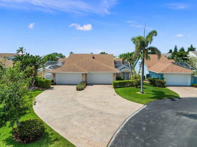 single story home featuring a garage and a front lawn