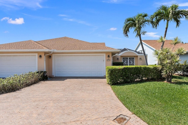 single story home featuring a garage and a front yard