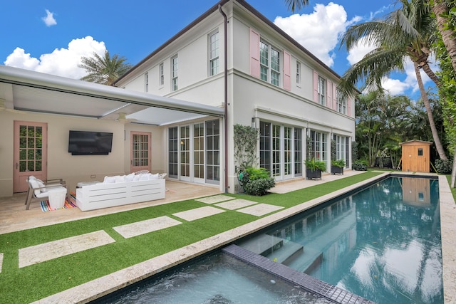 rear view of house with a shed, a patio, and an outdoor hangout area