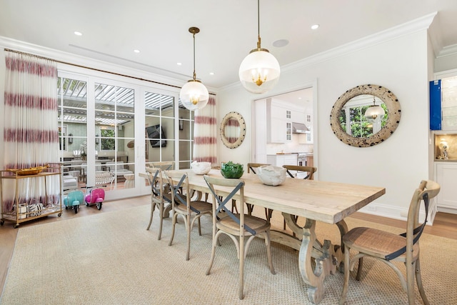 dining area featuring light wood-type flooring and ornamental molding