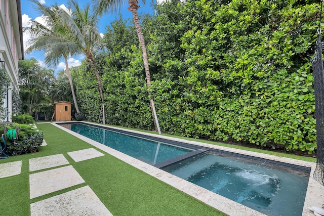 view of pool with a storage shed and an in ground hot tub