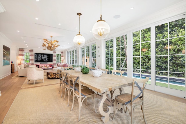 sunroom / solarium with plenty of natural light and a notable chandelier