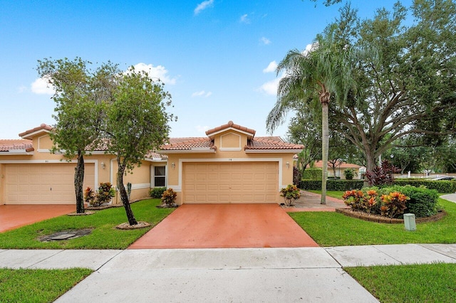 mediterranean / spanish-style home featuring a front lawn and a garage