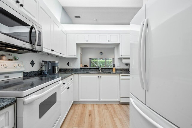 kitchen with white cabinets, white appliances, light hardwood / wood-style floors, and sink