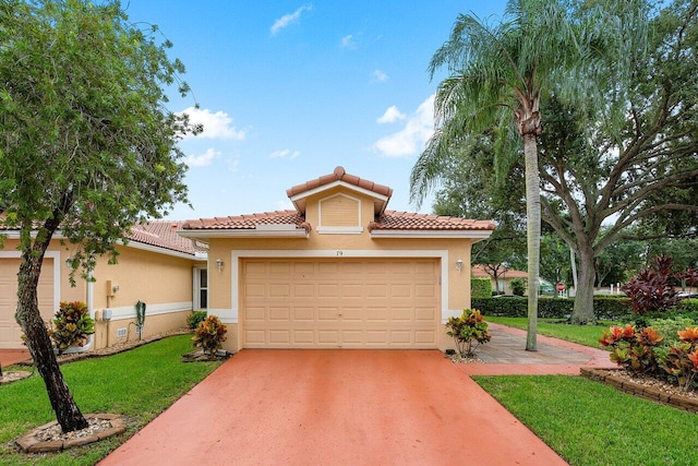 mediterranean / spanish-style home featuring a front yard and a garage