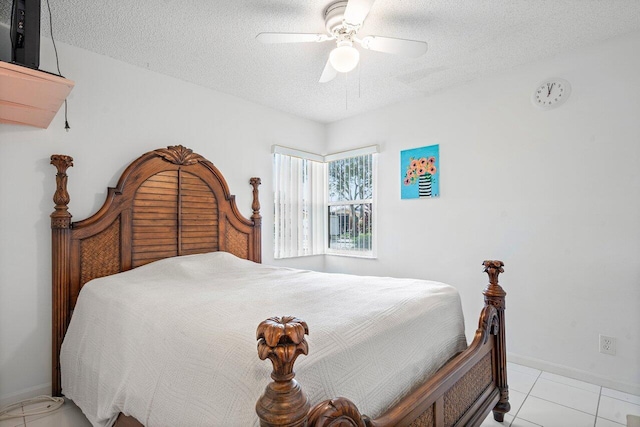 tiled bedroom with ceiling fan and a textured ceiling