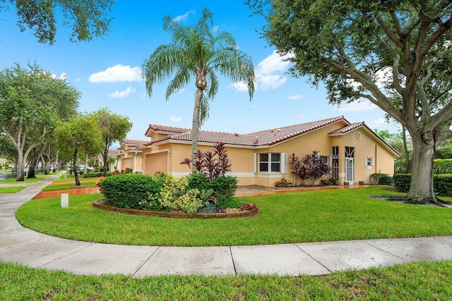 mediterranean / spanish house with a garage and a front lawn