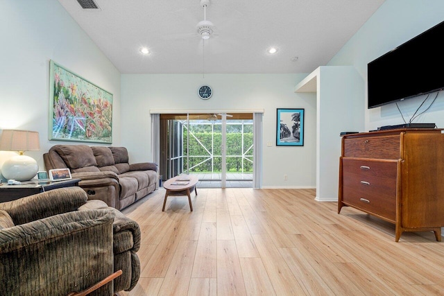 living room with ceiling fan, lofted ceiling, and light hardwood / wood-style floors