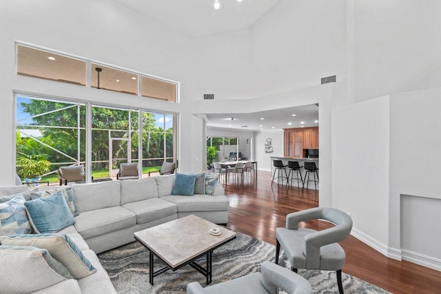 living room featuring a high ceiling and hardwood / wood-style flooring