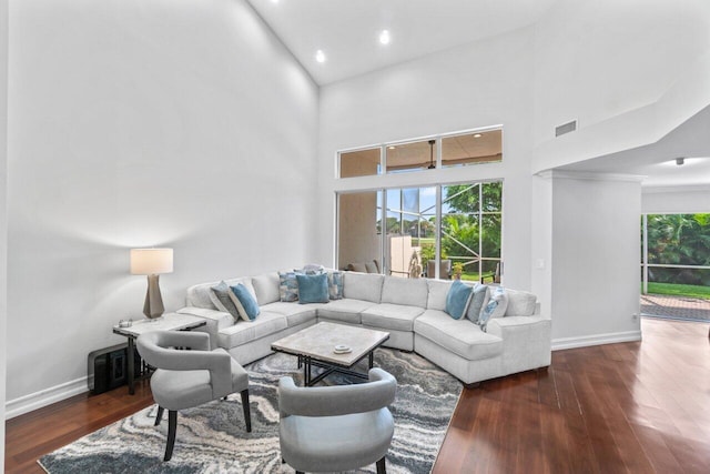 living room featuring high vaulted ceiling and dark wood-type flooring