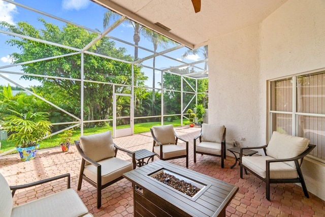 view of patio / terrace with an outdoor living space with a fire pit and a lanai