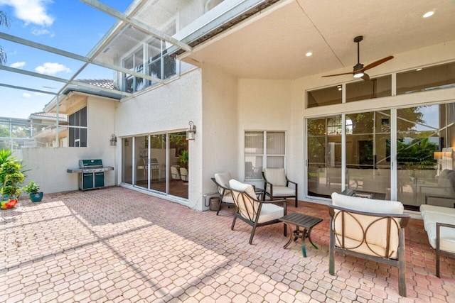 view of patio / terrace with glass enclosure, ceiling fan, and grilling area