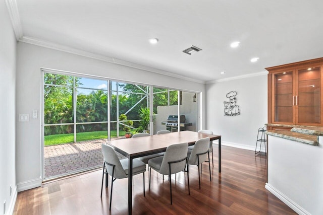 dining room with crown molding and dark hardwood / wood-style floors