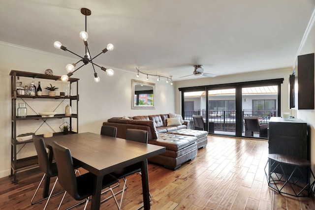 dining area with hardwood / wood-style floors, ceiling fan with notable chandelier, and ornamental molding