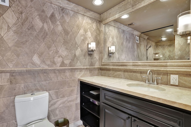 bathroom with vanity, toilet, and tile walls