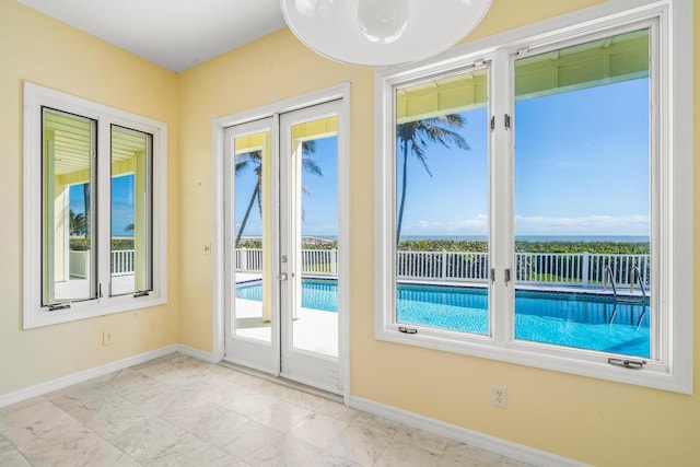 doorway with french doors, baseboards, and a healthy amount of sunlight