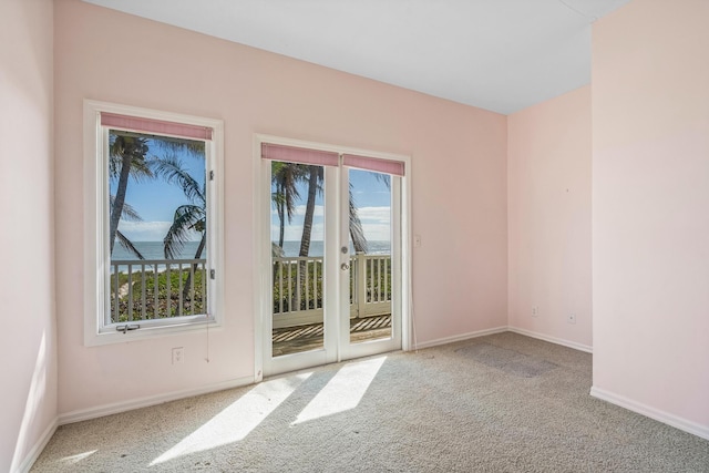 empty room featuring carpet and baseboards