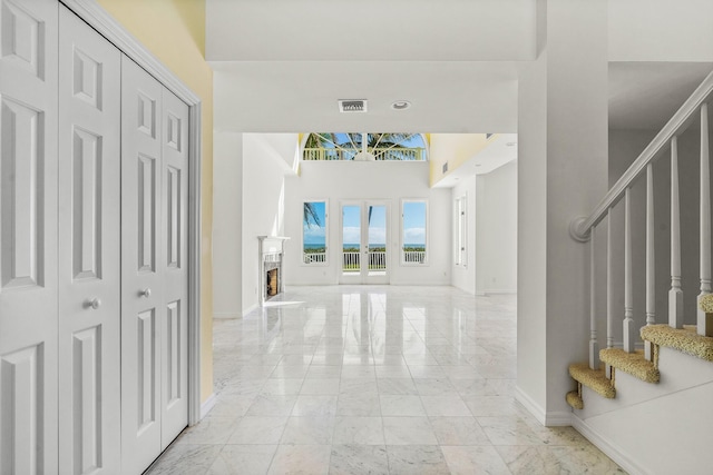 foyer entrance featuring stairway, baseboards, visible vents, and marble finish floor