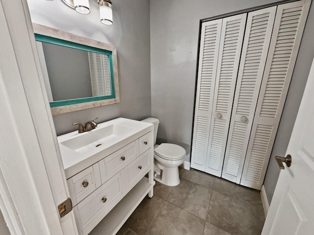 bathroom with tile flooring, vanity, and toilet