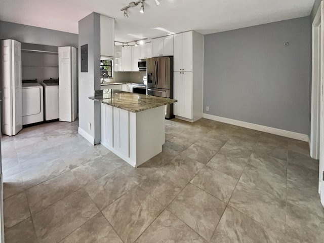 kitchen featuring white cabinetry, stainless steel appliances, dark stone counters, rail lighting, and light tile floors