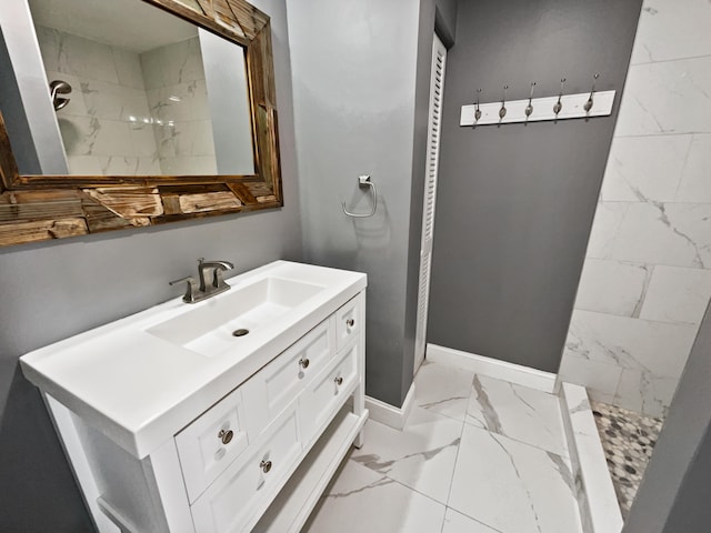 bathroom with tiled shower, tile flooring, and vanity