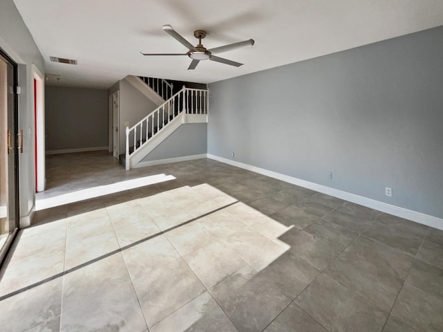 tiled empty room featuring ceiling fan