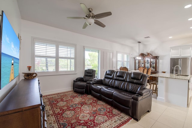 living room with plenty of natural light, ceiling fan, light tile patterned floors, and sink