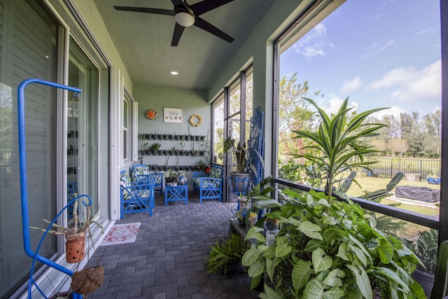 sunroom / solarium featuring ceiling fan