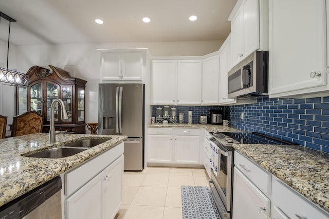 kitchen featuring decorative backsplash, appliances with stainless steel finishes, sink, pendant lighting, and white cabinets